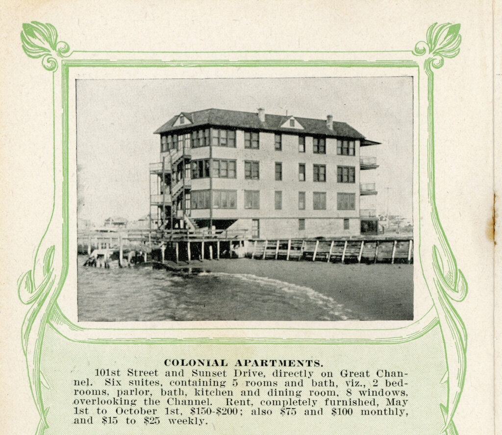 Printed real estate listing with a decorative green border, showing a photograph of a large three-story apartment building elevated on pilings over the waterfront, with multiple windows on each floor, exterior staircases, and dormer windows on the roof. The listing below identifies it as "Colonial Apartments" at 101st Street and Sunset Drive in Stone Harbor, NJ.